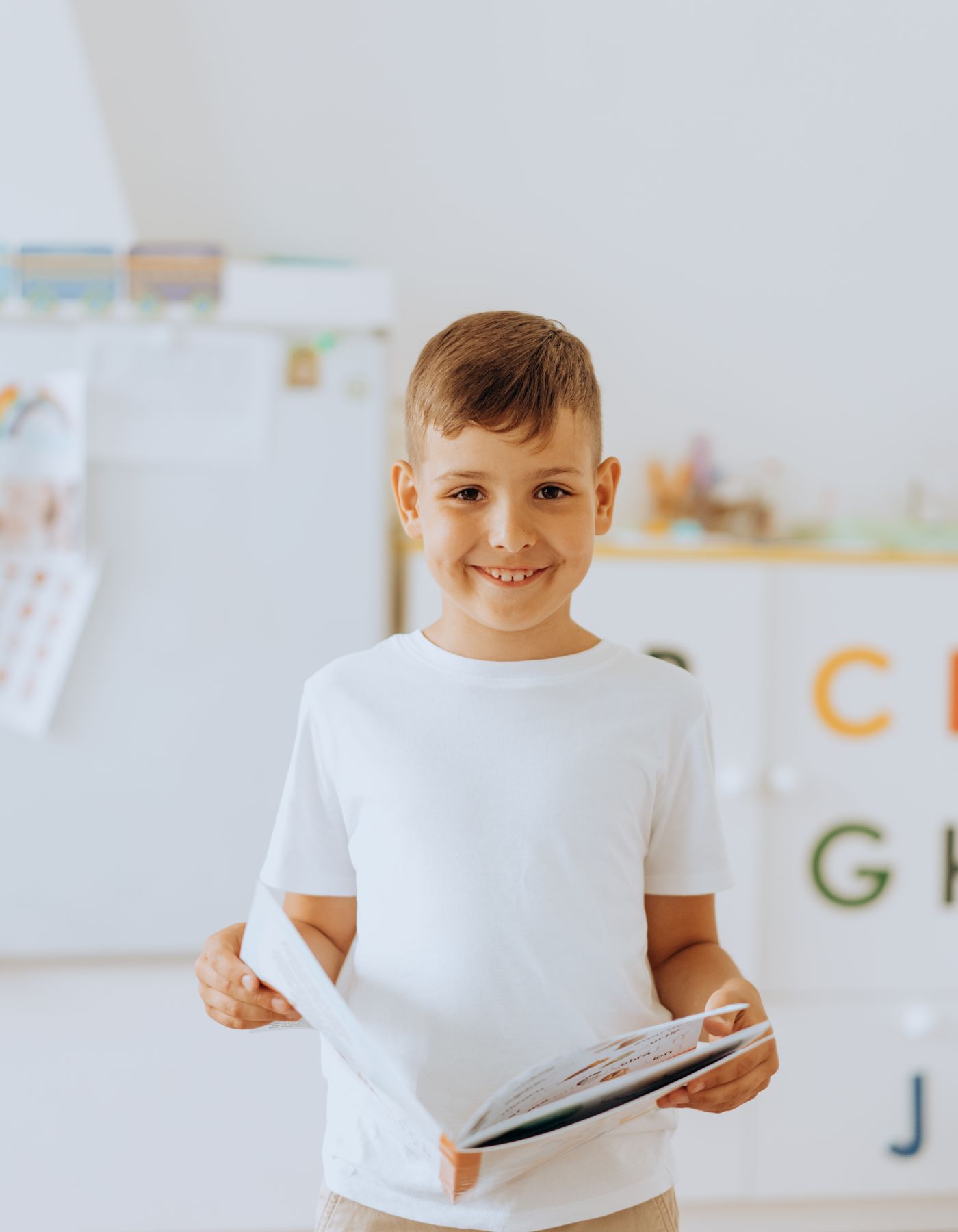 Niño sonriendo con un libro abierto
